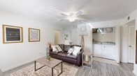 This well-organized 2-bedroom, 2-bathroom single-floor residence at 400 Hayden Rd in Tallahassee, Florida offers a practical and comfortable layout throughout. The living room features wood-look flooring, a ceiling fan, and an open feel that connects seamlessly to the rest of the home. A dedicated in-unit laundry area is conveniently accessible from the living space. The dining room is bathed in natural light from a large sliding glass door with vertical blinds that frame a lush outdoor view, creating an inviting atmosphere for everyday meals. The kitchen features light wood cabinetry, ample counter space on both sides, and a clean, functional galley-style layout. Both bedrooms offer ceiling fans, wood-look flooring, and well-sized closets—one bedroom includes a walk-in closet, while the primary bedroom provides a comfortable, serene retreat. The two bathrooms are straightforward and functional, each with a shower-tub combination. A welcoming entryway with light-toned walls and hard-surface flooring ties the home together. The consistent use of neutral tones and wood-look flooring throughout creates a cohesive, clean aesthetic across the entire residence.
