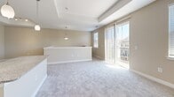 Located at 611 Wilbur Square in Owings Mills, MD, this multi-level home spans three floors and offers a well-organized layout with 2 bedrooms, 3 bathrooms, and a private garage. The entry-level garage features an automatic opener and provides convenient interior access via a staircase leading to the main living areas.

The main living floor is the heart of the home, where an open-concept kitchen and living area create a bright, welcoming atmosphere. The kitchen is outfitted with rich cherry-toned cabinetry, granite countertops, stainless steel appliances including a range, built-in microwave, and dishwasher, as well as a kitchen island with additional counter space. Light wood-style flooring adds warmth to the kitchen area, while the adjacent living space features plush carpet, a tray ceiling, pendant lighting, and sliding glass doors that open to a private balcony with neighborhood views.

The upper floor hosts the bedrooms, each carpeted and finished with neutral tones. The spacious primary bedroom includes a dedicated closet, while the second bedroom features a double-door closet and hallway access to shared spaces. The three bathrooms are finished with tile flooring, granite-topped vanities, and either a walk-in shower or a tub-shower combination, maintaining a consistent and polished aesthetic throughout the home.