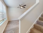 This 690-square-foot, two-story residence offers an efficient and well-designed layout spread across two floors of approximately 350 and 340 square feet, respectively. The main level features a bright living room with wood-look flooring, a ceiling fan with light fixture, and a large window that invites natural light and outdoor views. The adjacent kitchen is outfitted with stainless steel appliances including an electric range, over-the-range microwave, granite countertops, white shaker cabinetry, and a classic subway tile backsplash. A staircase connects the two levels. The upper floor houses the 180-square-foot primary bedroom, carpeted for comfort and featuring a dedicated closet. A second carpeted room with a large window provides additional flexible space. The full bathroom includes a white vanity with granite countertop, a large mirror with overhead lighting, and wood-look tile flooring. A separate laundry room with a washer and dryer completes the upper level. Throughout the unit, neutral tones, clean lines, and functional design elements contribute to a cohesive and move-in-ready living environment.
