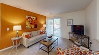 Located at 10017 Season Grove Ln. in Charlotte, NC, this single-story residence offers a thoughtfully laid-out floor plan designed for comfortable everyday living. The living room serves as the heart of the home, featuring plush carpeting, a bold accent wall, and sliding glass doors that open to a private outdoor patio, filling the space with natural light. A pass-through architectural detail connects the living area to adjacent spaces, adding an open, airy feel throughout.

The kitchen is outfitted with white cabinetry, white appliances including a range and refrigerator, a built-in dishwasher, and warm hardwood flooring that extends underfoot. Ample counter space and storage make this an efficient and functional cooking area.

The residence includes two well-sized bedrooms, each finished with soft carpeting and windows that invite natural light. One bedroom features a walk-in closet with built-in shelving, while the other benefits from direct access to an en-suite bathroom. Both rooms offer a calm, comfortable retreat.

Two full bathrooms serve the home, each featuring a vanity with a single sink, a tub-shower combination, and hardwood flooring. The layout provides both privacy and convenience for residents and guests alike. Overall, the home presents a clean, neutral palette that is welcoming and move-in ready.
