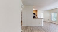 This 810-square-foot, single-floor apartment at 508 Jackson Downs Blvd in Nashville, Tennessee offers a practical and comfortable 2-bedroom, 2-bathroom layout. Light wood-tone flooring flows consistently throughout the unit, creating a cohesive and clean aesthetic. The combined kitchen and living area features light wood cabinetry, a peninsula with a double sink, black appliances including a refrigerator, range, and over-the-range microwave, and ample upper cabinet storage. The living room is bright and airy, showcasing an arched window flanked by standard windows that admit generous natural light, complemented by a ceiling fan. French doors in a secondary living area provide additional outdoor views and light. The primary bedroom spans 220 square feet and includes a ceiling fan, a closet, and a connected bathroom featuring a wood-tone vanity, tub-shower combo with white tile surround, and wood-look flooring. The second bedroom also features a ceiling fan, a window with outdoor views, and access to a hallway. The second bathroom includes a tub-shower with white tile and wood-look flooring. A hallway and closet complete the unit's functional floor plan.