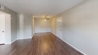 Located at 4201 W Adams Ave in Temple, Texas, this single-floor residence offers a practical and well-appointed layout throughout. The main living area features rich, dark hardwood-style flooring and a textured popcorn ceiling, with a ceiling fan providing comfort year-round. A standout feature is the set of French doors that flood the space with natural light and provide access to the outdoors. A second living or dining area continues the hardwood-style flooring and connects seamlessly to the kitchen, which is outfitted with white cabinetry, a double stainless steel sink, light countertops, and a full-size refrigerator. The bedrooms are carpeted for warmth and comfort, each equipped with ceiling fans and ample wall space. The full bathroom includes a wide vanity with a single sink, a large mirror, generous cabinet storage, and a tub-shower combination with built-in shelving. Neutral gray tones throughout the walls create a clean, cohesive aesthetic, while consistent trim and baseboards tie the interior together. The layout, as seen in the dollhouse view, flows logically between living, kitchen, and sleeping areas, making this a functional and comfortable single-level home.