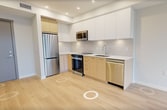 This contemporary 440 square foot apartment in Richmond offers a thoughtful blend of style and functionality. The open-concept layout maximizes the use of space, creating a seamless flow between the living areas. The kitchen is a highlight, boasting sleek white upper cabinets contrasted with warm wood lower cabinets, stainless steel appliances, and a convenient built-in microwave.

The living room and bedroom are bathed in natural light thanks to large windows that offer picturesque views of the surrounding greenery. Light-toned hardwood floors run throughout, enhancing the sense of spaciousness. The bedroom, measuring 90 square feet, features a built-in closet with sliding doors for efficient storage.

The bathroom is elegantly appointed with a modern vanity, white fixtures, and marble-look tiles, creating a spa-like atmosphere. Recessed lighting throughout the apartment adds to the contemporary ambiance. Despite its compact size, this well-designed space doesn't compromise on style or comfort, making it an ideal urban dwelling.
