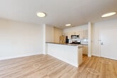 Located at 72 South Essex Avenue in Orange, NJ, this thoughtfully designed one-bedroom, one-bathroom residence offers a clean, modern aesthetic throughout its well-utilized single floor. Light wood flooring runs seamlessly across all areas, complementing the bright white walls and creating a cohesive, contemporary feel.

The open-concept kitchen and living area serves as the heart of the home. The kitchen features a peninsula with a dark countertop, light wood cabinetry, a stainless steel dishwasher and sink, a gas range, microwave, refrigerator, and a subway tile backsplash — providing both functionality and style. Flush ceiling lights illuminate the space, which flows naturally into the living area.

The bedroom is generously proportioned, benefiting from multiple black-framed windows that frame views of the surrounding Orange cityscape and fill the room with natural light. Two closets offer ample storage, including a walk-in closet with wire shelving.

The bathroom is finished with large-format tile surrounding a full soaking tub and shower, a modern vanity with a white countertop, wood-toned cabinetry, and a well-lit mirror. Additional conveniences include a dedicated laundry area and utility room, rounding out this efficiently designed and move-in-ready residence.