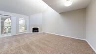 Located at 1801 E Girard Pl in Englewood, Colorado, this well-appointed two-bedroom, two-bathroom residence offers a comfortable and functional single-floor layout. The open kitchen is a standout feature, showcasing dark espresso cabinetry, granite countertops, a classic subway tile backsplash, and a full suite of stainless steel appliances including a refrigerator, range, microwave, and dishwasher. Light tile flooring ties the kitchen and living areas together seamlessly, while a distinctive arched window near the entry adds architectural character. The living room is generously sized, featuring vaulted ceilings that enhance the sense of openness, soft carpeting, and sliding glass doors that open to a private balcony with views of mature trees. Both bedrooms are carpeted and finished in neutral tones. The primary bedroom is spacious and includes dual closets and a window offering natural light and outdoor views. The second bedroom similarly benefits from natural light. Both bathrooms are finished with large-format stone-look tile surrounds on the tub and shower combinations, granite-topped vanities, and brushed nickel fixtures, lending a clean and polished aesthetic throughout.