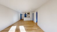Located on Third Avenue South in Birmingham, Alabama, this one-bedroom, one-bathroom unit offers a well-designed single-level layout that maximizes functionality throughout. The open-concept living and kitchen area serves as the heart of the unit, where warm light hardwood flooring stretches across a generously proportioned space. Natural light streams in through French doors framed in a striking cobalt blue, a design detail that repeats across interior doors throughout the unit, creating a bold, cohesive aesthetic against the crisp white walls.

The galley-style kitchen is well-appointed with gray shaker cabinetry, granite countertops, a subway tile backsplash, black hardware, and pendant lighting overhead. A peninsula provides additional counter space and separates the kitchen from the living area. The bedroom features plush carpeting, a ceiling fan, and a window allowing natural light. Two closets provide ample storage. The bathroom includes a gray vanity with granite countertop, a tub-shower combination, and hardwood-style flooring. A dedicated in-unit laundry space with full-size washer and dryer adds everyday convenience.