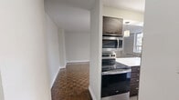 Located at 80 Wellesley Street East in Toronto's vibrant Church-Wellesley neighbourhood, this one-bedroom, one-bathroom unit on the fifth floor offers a well-appointed and efficiently designed living space. The open-concept kitchen and living area serves as the heart of the unit, highlighted by rich dark walnut cabinetry, white quartz countertops, a subway tile backsplash, and stainless steel appliances. A central kitchen island with pendant lighting provides additional workspace and casual seating, flowing seamlessly into the living area. Throughout the main living spaces and bedroom, classic parquet hardwood flooring adds warmth and a timeless character. The bedroom is a comfortable, well-proportioned room featuring a large window that fills the space with natural light and offers views of the surrounding Toronto cityscape, with a baseboard radiator providing supplemental heating. The bathroom is finished with large-format beige wall tiles, a glass-enclosed tub and shower combination, and stylish multi-bulb lighting, creating a clean and modern feel. Neutral grey tones throughout the unit contribute to a calm, cohesive ambiance suited to urban living.