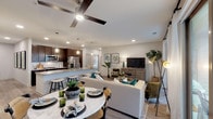 This single-story residence offers a thoughtfully designed open-concept floor plan that seamlessly connects the kitchen, dining, and living areas. The kitchen is a standout feature, showcasing rich dark-brown cabinetry, granite countertops, a subway tile backsplash, and stainless steel appliances. A spacious island with seating provides additional prep space and casual dining, while pendant lighting adds a polished finishing touch. Light wood-style flooring flows throughout the main living areas, enhancing the bright, airy atmosphere created by recessed lighting and ceiling fans.

The living area offers access to a private patio through sliding glass doors, bringing in natural light and outdoor views. A dedicated dining space accommodates a full table setup and sits adjacent to the living room for easy entertaining.

Both bedrooms feature plush carpeting, ceiling fans, and ample natural light from large windows. Each bedroom is paired with its own private bathroom, finished with dark cabinetry, granite vanity tops, and tub-shower combinations with clean tile surrounds. A convenient half-bath serves the main living areas. The primary bedroom includes a direct en-suite entry, adding an extra layer of privacy and functionality throughout the home.