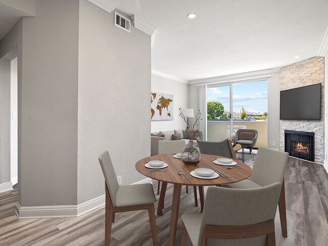 Hardwood floored dining room with view of balcony and stone walled fireplace. - Palms Court