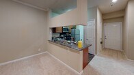 This single-floor unit located on Epworth Place in Durham, North Carolina, offers a well-organized layout with a cohesive design throughout. The kitchen is a functional centerpiece, featuring warm medium-toned wood cabinetry, dark granite-style countertops, a built-in dishwasher, stainless steel refrigerator, and a pass-through breakfast bar that opens directly to the carpeted living area. Crown molding accents the kitchen and living spaces, adding a polished architectural detail. The living room is generously proportioned, finished with neutral carpet and a sliding glass door that opens to a private balcony with views of surrounding greenery.

The bedrooms are carpeted and well-lit, each benefiting from large windows that frame outdoor tree views, creating a calm, natural atmosphere. Closet access is provided in each room.

The unit includes two bathrooms. One features wood-look plank flooring, a granite-topped vanity with warm wood cabinetry, a framed mirror, and a tub-shower combination. The second bathroom similarly offers granite counters, wood cabinetry, and a tub-shower with a glass enclosure, conveying a consistent and practical design throughout the entire space.