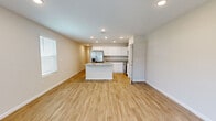 Located at 9756 Trout Tides Boulevard in Jacksonville, FL, this two-story home offers a well-designed layout spread across two floors. The main level features an open-concept living area and a modern kitchen equipped with crisp white shaker cabinets, granite countertops, a central island, and stainless steel appliances, including a refrigerator, range, and microwave. Light wood-look flooring flows consistently throughout the home, complementing the neutral, warm-toned walls and creating a cohesive, clean aesthetic. Recessed lighting illuminates the main living spaces efficiently.

The upper floor houses the bedrooms, including a primary suite with an en-suite bathroom featuring a dual-sink granite vanity, a walk-in tiled shower, and an adjacent walk-in closet. Additional bedrooms are generously sized, each offering natural light through blinded windows. Four full bathrooms serve the home across both levels. A dedicated laundry area with washer and water heater is tucked conveniently under the staircase. The attached garage provides additional storage and parking. Well-lit hallways connect the various rooms, giving the home a structured yet open feel throughout.