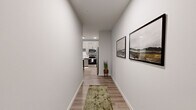 This well-designed 2-bedroom, 2-bathroom residence offers a thoughtfully laid-out single floor with modern finishes throughout. A clean, light-filled hallway with light wood-style flooring and crisp white walls welcomes you in, leading to the main living areas.

The kitchen is a standout feature, showcasing light gray two-tone cabinetry with matte black hardware, white quartz countertops, a marble-style tile backsplash, and a full suite of stainless steel appliances. Recessed lighting and wood-look flooring complete the polished, functional space.

The living room offers a comfortable, airy atmosphere with natural light streaming through large windows dressed with elegant draping curtains, complemented by the same hardwood-style flooring that runs throughout the main areas.

The spacious primary bedroom features plush carpeting, a distinctive teal accent wall, a window allowing natural light, and a generous walk-in closet with wire shelving. The second bedroom is equally well-appointed with soft carpet and neutral tones.

Both bathrooms echo the home's modern aesthetic, featuring wood-toned vanities with white countertops, matte black hardware, and a tub-shower combination. Two closets provide abundant storage throughout the residence, rounding out this refined and functional living space.