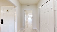 Located at 2857 Entry Point Rd in Kissimmee, FL, this well-appointed single-floor residence offers 2 bedrooms and 4 bathrooms with a cohesive modern aesthetic throughout. Light hardwood-style flooring flows across the main living areas, complementing the neutral palette and creating a bright, airy atmosphere.

The open-concept living room features a tray ceiling with a ceiling fan, recessed lighting, and expansive floor-to-ceiling sliding glass doors that lead to an outdoor patio, offering pleasant views of the surrounding landscape. The adjacent dining area is anchored by a bold gold multi-light chandelier above a large rectangular dining table, with ample natural light from multiple windows. The kitchen is outfitted with white shaker cabinetry, quartz countertops, marble-look tile flooring, and a full suite of stainless steel appliances.

The primary bedroom is generously sized, featuring light hardwood floors, a ceiling fan, and a stylish sliding barn door leading to its en-suite bathroom. The second bedroom comfortably accommodates two beds with warm wood headboards and offers outdoor views. The four bathrooms are finished with marble-look tile, white quartz vanities, and glass-enclosed showers — with one standout bathroom housing a large jetted soaking tub set into the floor, offering a spa-like experience.