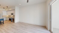 Located at 2335 NE 186th St, Unit 312 in Miami, FL, this well-appointed one-bedroom, one-bathroom unit offers a thoughtfully designed layout with modern finishes throughout. Light wood-style flooring flows seamlessly across all living areas, creating a bright and cohesive aesthetic.

The open-concept kitchen is a standout feature, showcasing floor-to-ceiling white cabinetry, a large center island with a white quartz countertop, stainless steel appliances including a French door refrigerator, range, and microwave, as well as a dedicated wine cooler. Recessed and track lighting illuminate the space efficiently.

The living room is generously proportioned, featuring a ceiling fan, recessed lighting, and expansive sliding glass doors that invite abundant natural light and provide views of the surrounding community with tropical greenery.

The bedroom is a comfortable retreat, also equipped with a ceiling fan and large sliding glass doors that open to a private balcony area with outdoor views. The bathroom is finished with clean tile flooring, a glass-enclosed walk-in shower with elegant tilework and matte black fixtures. Adjacent to the bathroom is a dedicated walk-in closet outfitted with custom built-in shelving and drawers. A hallway connects all spaces efficiently, completing this clean, modern Miami residence.