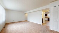 Located at 1580 Prospect St in Elyria, Ohio, this two-floor residence offers a straightforward and functional layout spread across two levels. The main living area is generously sized, featuring neutral-toned wall-to-wall carpeting and a partially open connection to the kitchen, creating a cohesive flow between spaces. The kitchen is equipped with dark espresso cabinetry, a gas range, a full-size refrigerator, and tile flooring, providing ample storage and workspace. Adjacent to the kitchen is a closeted utility or storage area with louvered doors. The bedrooms are carpeted and well-proportioned, each benefiting from natural light through standard windows. One bedroom features a ceiling fan with light fixture and a closet with bifold doors, while another includes a built-in closet and views of the surrounding neighborhood. The full bathroom on the upper level is outfitted with a tub-shower combination, a dark-finish vanity with a marble-patterned countertop, a medicine cabinet mirror, and tile flooring. A half bathroom on the lower level provides convenient powder room access. Throughout, the interiors maintain a clean, neutral palette with white walls and light trim, lending a versatile canvas well-suited for a variety of uses.
