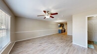 Located at 2833 S Adams St in Tallahassee, Florida, this two-story home offers four bedrooms and four bathrooms thoughtfully distributed across two floors. The layout provides a generous and functional living environment, with the ground floor dedicated primarily to common living areas and the upper floor housing additional private spaces.

The main living area is bright and welcoming, featuring light wood-look flooring, neutral warm-beige walls, and a ceiling fan with light fixture that adds both comfort and character. Natural light filters in through large windows fitted with blinds, creating an airy atmosphere throughout. A staircase connects the two floors, and a hallway guides residents through the layout efficiently.

The galley-style kitchen is a standout feature, equipped with dual-toned blue-gray cabinetry, white countertops, a stainless steel double sink, and black appliances including a refrigerator, stove, and dishwasher. Track lighting overhead adds a practical, modern touch, and the kitchen opens toward the main living area, enhancing the sense of flow.

The four bathrooms are clean and functional, featuring light blue-gray vanities with white countertops, tile-surround bathtubs, wood-look flooring, and well-lit mirrors. The primary bedroom benefits from vaulted ceilings, a ceiling fan, and a sliding closet door with outdoor views. A dedicated utility room provides added convenience. Consistent finishes throughout give the home a cohesive, well-maintained feel.