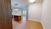 Located at 420 Salt Meadow Cir in Bradenton, Florida, this single-floor residence offers a well-designed layout that maximizes comfort and functionality. The open-concept living, dining, and kitchen area serves as the heart of the home, featuring warm wood-look laminate flooring, neutral tones, and a ceiling fan that enhances airflow throughout the space. An elegant arched doorway adds architectural character to the open floor plan.

The kitchen is a standout feature, showcasing rich dark wood cabinetry extending to the ceiling, light granite countertops, a tiled mosaic backsplash, and black appliances including a refrigerator, range, dishwasher, and built-in microwave. A central island with additional cabinetry and pendant lighting above provides extra prep space and visual appeal. Track lighting adds a modern touch overhead.

The bedroom is carpeted for comfort and receives natural light through sizable windows fitted with blinds, complemented by a ceiling fan. Four closets throughout the unit provide exceptional storage capacity. A versatile den offers additional flexible living space, also with carpet and natural light. The bathroom is cleanly finished with tile flooring, a tub-shower combination, and granite-topped vanity. A dedicated laundry area and utility room round out this thoughtfully arranged home.