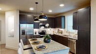 Located in Round Rock, TX, this thoughtfully designed two-bedroom, two-bathroom residence features a single-floor layout that balances functionality and modern style throughout. The entryway welcomes you with wood-look plank flooring and a clean, bright hallway that connects the living spaces seamlessly.

The kitchen is a standout, showcasing dark espresso shaker cabinets, granite countertops, a subway tile backsplash, and a full suite of stainless steel appliances. A center island with pendant lighting serves as both a prep space and casual gathering spot.

The living area is filled with natural light from large windows and a sliding glass door that opens to a private balcony offering open, scenic views of the surrounding landscape.

Both bedrooms feature plush carpet, ceiling fans, and generous windows. The primary bedroom connects to an en-suite bathroom with a double-sink granite vanity, dark cabinetry, wood-look flooring, and a glass-enclosed walk-in shower. The second bathroom mirrors the refined finishes with a granite vanity and ample storage cabinetry.

Throughout the home, neutral tones, recessed lighting, and consistent high-quality finishes create a cohesive and inviting atmosphere well-suited for comfortable everyday living.