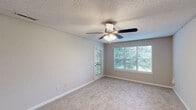 Located at 709 Patriot Pkwy in Rock Hill, SC, this single-story, 3-bedroom, 2-bathroom home offers a well-organized layout with a comfortable blend of functional spaces. The kitchen is a standout feature, showcasing gray shaker-style cabinetry, granite countertops, a subway tile backsplash, and black appliances including a range and refrigerator. Wood-look flooring runs through the kitchen and living areas, lending warmth and easy maintenance to the main living spaces. The combined kitchen and living room area provides an open, practical flow for everyday living. Each of the three bedrooms is carpeted for comfort and receives natural light through windows with blinds. The generously sized primary bedroom includes a ceiling fan and direct access to a closet. The additional bedrooms are well-proportioned, with neutral wall tones and ceiling-mounted lighting. Both bathrooms feature tub-shower combinations with chrome fixtures and clean, white surrounds. The home also includes a dedicated utility room and a closet for added storage. Textured ceilings and ceiling fans are present throughout multiple rooms, contributing to a practical and classic interior aesthetic suited for a variety of lifestyles.