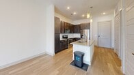 Located at 850–856 Greenside Dr in Richardson, TX, this single-story one-bedroom, one-bathroom unit offers a thoughtfully designed layout with contemporary finishes throughout. Light wood-style flooring runs continuously across the living areas and bedroom, creating a cohesive and clean aesthetic.

The kitchen serves as a central feature, anchored by a granite-topped island with an undermount sink and pendant lighting overhead. Dark espresso cabinetry provides ample storage and contrasts sharply with the light countertops and subway tile backsplash. Stainless steel appliances, including a range, microwave, and refrigerator, complete the space. The kitchen opens toward the living area, which benefits from natural light through glass-paned doors and a ceiling fan.

The bedroom is generously sized, featuring a ceiling fan, a natural light-filled window with blinds, and direct access to both the bathroom and a dedicated closet. The closet is well-organized with built-in shelving and hanging rods.

The bathroom is finished with large-format tile flooring, dark cabinetry, granite countertops, an undermount sink with brushed nickel fixtures, and a framed mirror. A walk-in closet is accessible directly from the bathroom, outfitted with adjustable shelving. The overall ambiance is modern, neutral, and move-in ready.