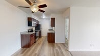 Located at 59 Reid Terrace in Fond du Lac, Wisconsin, this single-floor, one-bedroom, one-bathroom residence offers a functional and comfortable layout with quality finishes throughout. The open-concept living, dining, and kitchen area serves as the heart of the home, featuring light-toned luxury vinyl plank flooring and a ceiling fan that enhances air circulation and comfort. The galley-style kitchen is well-equipped with rich, dark-stained wood cabinetry, granite countertops, stainless steel appliances including an electric range, microwave, refrigerator, and dishwasher, along with a deep undermount sink with a pull-down faucet — making it both practical and visually appealing. A hallway connects the main living area to the private bedroom, which features classic hardwood flooring, a ceiling fan, a baseboard heating unit, and a window that allows natural light and neighborhood views. Two closets provide ample storage throughout the unit. The bathroom is cleanly finished with marble-style tile surrounding the shower/tub combo, a white vanity with sink, wood-toned storage cabinetry, and contemporary lighting. The overall ambiance is bright, clean, and move-in ready, offering a cohesive and comfortable living environment.