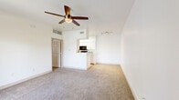 Located at 550 N Harrison Rd in Tucson, Arizona, this single-story, one-bedroom, one-bathroom residence offers a clean and functional layout designed for comfortable everyday living. The open-concept living room and kitchen area is bright and airy, featuring neutral-toned carpeting, crisp white walls, and a ceiling fan with light fixture. A sliding glass door leads to a private balcony, filling the space with natural light and providing outdoor access. The kitchen is laid out in a galley-style configuration, appointed with white cabinetry, light countertops, and black appliances including a refrigerator, range, and over-the-range microwave. Wood-look flooring in the kitchen adds a warm contrast to the rest of the home. The bedroom is a comfortable, well-proportioned retreat featuring soft carpeting, a ceiling fan, and a window with blinds that allow for natural light and privacy. A dedicated closet provides convenient storage. The bathroom is neatly finished with a white vanity, granite-style countertop, a mirrored medicine cabinet, and a tiled tub-shower combination. Throughout the home, the consistent use of white tones and clean finishes creates a cohesive, move-in-ready aesthetic suited for Tucson's sunny climate.