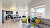 This thoughtfully designed 2-bedroom, 2-bathroom residence offers a seamless open-concept layout connecting the living, dining, and kitchen areas. Light wood-style flooring flows throughout the main living spaces, complemented by crisp white walls and large windows that flood the interior with natural light and frame scenic outdoor views.

The kitchen is equipped with stainless steel appliances, dark espresso cabinetry, light quartz countertops, and a peninsula with bar seating — ideal for casual dining and entertaining. Adjacent to the kitchen, the dedicated dining area features a wall of windows overlooking open green landscapes, creating a bright and inviting atmosphere. The living room extends to large windows and balcony access, offering additional outdoor views.

A well-organized hallway connects the private quarters, which include two generously sized bedrooms. The primary bedroom features a ceiling fan, direct access to a dedicated bathroom with a quartz vanity and dark cabinetry, and a walk-in closet. The second bedroom enjoys abundant natural light through a wide window with pastoral views. Each bedroom includes dedicated closet space.

Both bathrooms are finished consistently with dark vanity cabinetry, quartz countertops, and light wood-style flooring. The unit also includes a hallway workspace nook, adding functional versatility to the overall layout.