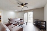 Located at 869 Port Republic Rd in Harrisonburg, VA, this single-story, 4-bedroom, 2-bathroom home offers a well-organized layout across a comfortable footprint. The living room is a welcoming central space featuring hardwood-style flooring, a ceiling fan with light fixture, and a sliding glass door that opens to an outdoor patio, filling the room with natural light. Adjacent to the living room, the dining area provides a seamless flow for everyday living and entertaining.

The kitchen is a standout feature, showcasing granite countertops, white shaker-style cabinetry with black hardware, a classic subway tile backsplash, a deep stainless steel sink with a modern gooseneck faucet, and black appliances including a range, microwave, and refrigerator. A skylight adds additional brightness to this functional space.

The four bedrooms are carpeted and comfortably sized, each offering windows for natural light and ample closet storage — the home includes an impressive eight closets throughout. The two bathrooms are clean and practical, featuring white vanities, framed mirrors, and a tub-shower combination. Three hallways connect the spaces efficiently, contributing to a smooth and functional floor plan throughout the home.