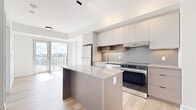 Located at 280 Montgomery Street in Ottawa's vibrant Vanier neighbourhood, this thoughtfully designed one-bedroom, one-bathroom unit offers a contemporary living experience within a compact yet efficiently organized floor plan. Light hardwood flooring runs throughout, complementing the bright, white walls and creating a clean, cohesive aesthetic.

The open-concept living, dining, and kitchen area forms the heart of the unit. The modern kitchen is outfitted with flat-panel grey cabinetry, a tile backsplash, warm wood open shelving, stone countertops, and a full suite of stainless steel appliances including a dishwasher and range. A central island provides additional prep space and casual seating. Large floor-to-ceiling windows and a glass door lead to a balcony, flooding the living area with natural light and offering sweeping views of the Ottawa skyline and tree canopy below.

The bedroom is a quiet, well-proportioned retreat featuring a mirrored sliding-door closet and a large window framing lush outdoor views. The four-piece bathroom is finished with stone-look tile flooring, a grey vanity with stone countertop, a framed mirror, and a glass-enclosed walk-in shower with white subway tile. In-unit laundry and a dedicated entrance complete this well-appointed space.