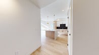Located at 300 Enterprise Blvd in Bozeman, Montana, this contemporary 2-bedroom, 2-bathroom residence showcases thoughtful modern design throughout. The open-concept living area impresses with soaring ceilings accented by exposed wood beams and large sliding glass doors that flood the space with natural light and open to a private balcony overlooking the surrounding Bozeman landscape. Light wood-style flooring runs throughout the main living areas, complementing the bright, airy atmosphere.

The kitchen is a standout feature, centering on a generous waterfall quartz island with sleek black hardware. Natural wood cabinetry pairs with crisp white upper cabinets and a dramatic dark marble tile backsplash. Stainless steel appliances, including a French door refrigerator, complete the culinary space. Gold pendant lights overhead add a warm, refined touch.

The spacious primary bedroom is carpeted for comfort and connects directly to an en-suite bathroom featuring a marble-tiled walk-in shower, a floating wood vanity with dual sinks, a gold-framed mirror, and elegant wall sconces. A generously sized walk-in closet with built-in shelving and hanging rods completes the suite. The second bedroom and additional full bathroom offer equally well-appointed accommodations, rounding out this polished Bozeman residence.