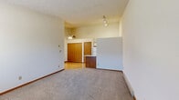 Located at 12059 Muirwood Dr in Zanesville, Ohio, this single-floor, 2-bedroom, 1-bathroom unit offers a practical and comfortable layout. The open living area features neutral carpeting, a baseboard heating system, and track lighting mounted on tall ceilings, creating a bright and airy atmosphere. A half-wall partition thoughtfully separates the living space from the adjacent kitchen, which includes wooden cabinetry, a white refrigerator, and hardwood-style flooring that adds warmth to the space.

The generously sized primary bedroom is highlighted by a ceiling fan, plush carpeting, a textured ceiling, and a large double sliding closet with warm wood-toned doors. A second bedroom offers similar carpeted flooring, a ceiling fan, a textured ceiling, a window with outdoor views, and a baseboard heater, ensuring comfort throughout the seasons. One bedroom also features a wall-mounted air conditioning unit for additional climate control.

The full bathroom is clean and functional, featuring a white tub-shower combination with chrome fixtures and hardwood-style flooring. Throughout the unit, neutral tones, warm wood accents, and consistent flooring choices create a cohesive and inviting living environment.