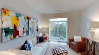 The Kirkpatrick floor plan is a thoughtfully designed 1-bedroom, 1-bathroom residence that maximizes comfort and functionality across a single level. The living area serves as the heart of the home, featuring neutral-toned walls that create a warm and versatile backdrop for any décor style. Large sliding glass doors flood the space with abundant natural light and open directly onto a private balcony, offering pleasant outdoor views of lush greenery. The living room provides ample space for comfortable seating arrangements and is complemented by smooth ceilings with standard ceiling height and hard-surface flooring that adds a clean, modern aesthetic. The kitchen and dining areas are designed for everyday convenience, flowing naturally from the main living space. The bedroom offers a private retreat with generous proportions, while the bathroom is well-appointed to meet daily needs. Throughout the residence, the layout emphasizes an open, airy feel, making the space feel inviting and efficient. The combination of natural light, private outdoor access, and a cohesive neutral palette gives the Kirkpatrick a bright, contemporary character suited for comfortable everyday living.