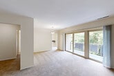 Located at 2020 Brooks Dr in District Heights, MD, this single-floor, 2-bedroom, 2-bathroom residence offers a functional and well-organized layout. The living room is a standout space, featuring plush carpeting, a pendant light fixture, and expansive sliding glass doors that open to a private balcony overlooking lush greenery, flooding the area with natural light. The kitchen is equipped with a gas range, light wood cabinetry, tile flooring, granite-style countertops, and a convenient wall-mounted shelf for additional prep or storage space. A central hallway connects the main living areas to the private quarters, where two carpeted bedrooms provide comfortable retreats. The primary bedroom is generously sized, offering dual windows with tree-lined views and direct access to a dedicated closet. The second bedroom is equally well-lit and provides its own closet access. Both bathrooms are cleanly finished, featuring tile flooring, wood-toned vanity cabinetry, white countertops with integrated sinks, and mirrored vanities. One bathroom includes a tiled tub-shower combination. Throughout the residence, neutral wall tones and consistent carpeting create a cohesive, calm ambiance. Four closets throughout the home provide abundant storage options.