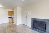 This 490-square-foot, one-bedroom, one-bathroom apartment is located at 2601 E McKellips Rd in Mesa, AZ. The single-floor layout makes efficient use of space across a kitchen/living room, bedroom, bathroom, hallway, and closet. The living room serves as the heart of the unit, featuring wood-look tile flooring, a ceiling fan with light fixture, and a standout granite-surround fireplace that adds character to the space. Sliding glass doors open to a private balcony, bringing in natural light and outdoor views of the surrounding landscaped grounds. The kitchen is appointed with warm oak cabinetry, dark granite-style countertops, a tile-look floor, and white appliances including an electric range and refrigerator. The 130-square-foot primary bedroom offers plush carpeting, a ceiling fan, a window for natural light, and access to a dedicated closet. The full bathroom mirrors the kitchen's design aesthetic, featuring matching oak cabinetry, dark countertops, a large mirror, and a full tub/shower combination. Neutral tones throughout the unit create a clean, cohesive ambiance well-suited for comfortable everyday living in the Mesa, Arizona area.