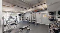 Located at 35 Southwest 6th Avenue in Miami's vibrant Brickell neighborhood, this fitness center offers a well-appointed exercise space designed to support a comprehensive workout routine. The single-level gym features an industrial-style aesthetic, with an exposed concrete ceiling, visible HVAC ductwork, and linear fluorescent lighting that gives the space a clean, functional character. Dark rubber flooring throughout provides both durability and comfort underfoot.

The cardio zone is anchored by a row of Star Trac treadmills and an elliptical trainer positioned alongside floor-to-ceiling glass windows, flooding the area with natural light and offering open views of the surrounding streetscape. A wall-mounted television provides entertainment during workouts.

The strength training section is well-equipped with a Hoist multi-station cable machine, a variety of selectorized weight machines, and adjustable benches suited for a range of exercises. A dedicated free weights area features a full rack of dumbbells and a large wall mirror, allowing users to monitor their form. The space is efficiently organized to maximize the available floor area while maintaining clear pathways between equipment stations. Overall, the gym delivers a practical and fully functional fitness environment in the heart of Miami.