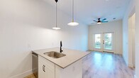 Located at 3200 Medical Center Drive in McKinney, TX, this thoughtfully designed two-bedroom, one-bathroom residence offers a clean, modern aesthetic across its single floor. Light wood-style flooring flows throughout the space, complementing the crisp white walls and creating a bright, cohesive atmosphere.

The open-concept kitchen serves as the heart of the home, featuring a peninsula with a light quartz countertop, undermount sink, and matte black fixtures. White shaker-style cabinetry with black hardware is paired with stainless steel appliances, including a refrigerator, range, microwave, and dishwasher. Stylish pendant lights hang above the peninsula, and the kitchen opens seamlessly into the living area, which benefits from a ceiling fan and French doors that invite natural light and outdoor views.

Both bedrooms are bright and airy, each with windows fitted with blinds that allow for ample natural light. The rooms feature the same warm wood-style flooring and clean white walls, offering a versatile and inviting atmosphere. A dedicated closet provides practical storage.

The bathroom is well-appointed with a tub-shower combination, large-format tile surround, and wood-style flooring that ties the space together. A programmable thermostat adds a layer of comfort and convenience to this efficiently designed home.
