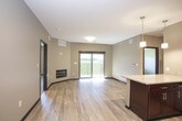 This single-floor, two-bedroom residence offers a thoughtfully designed layout that balances functionality with modern aesthetics. The open-concept kitchen serves as the centerpiece of the living area, showcasing rich dark-mahogany cabinetry, granite countertops, and a full suite of stainless steel appliances including a refrigerator, range, microwave, and dishwasher. A kitchen island with pendant lighting above provides additional workspace and a natural gathering point. Light wood-style flooring runs throughout the kitchen and main living areas, lending warmth and visual continuity.

Both bedrooms are generously proportioned, finished with plush carpeting, neutral taupe walls, ceiling fans, and windows fitted with blinds that allow natural light to filter in. The bathrooms are finished to a consistent standard, each featuring granite-topped vanities with dark wood cabinetry, undermount sinks, large mirrors, and light wood-style flooring. One bathroom includes a full tub-shower combination with a curved rod. The overall color palette throughout the residence is neutral and cohesive, creating a clean, move-in-ready environment with a contemporary feel.