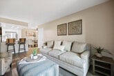 Located at 1265 E 9th St in Upland, California, this single-floor unit offers a well-designed layout with a clean, neutral aesthetic throughout. The living area is a standout feature, boasting soaring vaulted ceilings that lend an open, airy feel to the space. Plush carpeting runs throughout the living and bedroom areas, adding warmth and comfort underfoot. A sliding glass door floods the living room with natural light and provides direct access to an outdoor balcony, offering pleasant views of the surrounding neighborhood.

The kitchen is thoughtfully appointed with crisp white cabinetry, light wood-tone luxury vinyl plank flooring, and a full suite of stainless steel appliances including a gas range, over-the-range microwave, dishwasher, and refrigerator. Recessed lighting illuminates the space from a tray ceiling, giving the kitchen a polished, modern look.

The bedroom is generously proportioned, featuring vaulted ceilings, soft carpet, and a window with vertical blinds that allow for natural light and outdoor views. A large walk-in closet with built-in clothing rods provides ample storage. Additional doors in the main living area lead to utility and storage spaces, completing this functional and well-appointed home.