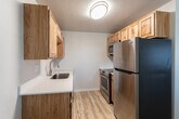 Located at 543 S Curtis Rd in Boise, Idaho, this single-level 2-bedroom unit offers a clean, functional layout with consistent light hardwood-style flooring running throughout every room, creating a cohesive and easy-to-maintain living environment.

The living area is well-proportioned and filled with natural light through a large window fitted with horizontal blinds. A ceiling fan with a built-in light fixture provides both comfort and illumination. The space also features a large double-door closet, adding notable storage capacity to the main living area.

The kitchen is efficiently designed with warm-toned natural wood cabinetry extending to upper and lower sections, white countertops, a stainless steel sink, dishwasher, and refrigerator. Sunlight reflects off the flooring, keeping the kitchen feeling bright and welcoming.

Both bedrooms are comfortably sized, each featuring a window with blinds, baseboard heating, and a ceiling fan. One bedroom includes a double-door closet with ample storage. The neutral wall tones in each room create a calm, versatile atmosphere.

The bathroom features a white vanity with a large mirror, white countertop with under-sink storage, and a shower-tub combination. The hardwood-style flooring extends into the bathroom, maintaining design continuity throughout the unit.
