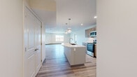 Located at 2305 Sokol Ct in Darien, IL, this well-appointed 2-bedroom, 2-bathroom residence offers a thoughtfully designed single-level layout with modern finishes throughout. Light wood-style flooring flows seamlessly across the entire space, creating a cohesive and contemporary aesthetic.

The open-concept kitchen and living area serves as the heart of the home. The kitchen is equipped with stainless steel appliances, including a gas range, microwave, and refrigerator, complemented by warm wood-tone cabinetry, a white subway tile backsplash, and a curved center island with a quartz countertop and pendant lighting overhead. The adjacent living room benefits from natural light and access to a private balcony through sliding glass doors, offering pleasant outdoor views.

Both bedrooms are well-proportioned, featuring large windows with views of the surrounding greenery, and light-filled, neutral interiors. The primary bedroom includes a spacious walk-in closet outfitted with wire shelving and a ceiling fan for added comfort. The second bedroom also enjoys ample natural light.

The bathrooms are finished with marble-look tile on floors and walls, warm wood vanities, white quartz countertops, and illuminated mirrors, lending a clean and polished look. Recessed lighting throughout the home adds to its bright, modern ambiance.