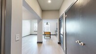 Located at 1220 Second Ave N in Nashville, Tennessee, this single-floor unit offers a thoughtfully designed open layout that maximizes every square foot. The combined kitchen and living area forms the heart of the space, where light hardwood flooring runs continuously underfoot, creating a bright and cohesive feel. Natural light enters through multiple windows fitted with blinds, illuminating the open floor plan.

The kitchen is well-appointed with dark-toned wood cabinetry, dark granite countertops, and a full suite of stainless steel appliances including an electric range, dishwasher, and refrigerator. A stainless steel wall-mounted range hood sits above the stove, complemented by a textured tile backsplash that adds visual depth. An industrial-style kitchen island with a butcher block top and open shelving serves as a functional centerpiece and natural divider between the kitchen and living zones.

The living area is open and versatile, with a structural column adding architectural character. A hallway connects the main living space to the bathroom, which features a full soaking tub with white subway tile surround, a wood-cabinet vanity, and clean, neutral finishes. The overall aesthetic is modern and understated, with neutral walls, dark baseboards, and high ceilings enhancing the sense of openness throughout.