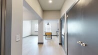 Located at 1220 Second Ave N in Nashville, Tennessee, this single-floor unit offers a thoughtfully designed open layout that maximizes every square foot. The combined kitchen and living area forms the heart of the space, where light hardwood flooring runs continuously underfoot, creating a bright and cohesive feel. Natural light enters through multiple windows fitted with blinds, illuminating the open floor plan.

The kitchen is well-appointed with dark-toned wood cabinetry, dark granite countertops, and a full suite of stainless steel appliances including an electric range, dishwasher, and refrigerator. A stainless steel wall-mounted range hood sits above the stove, complemented by a textured tile backsplash that adds visual depth. An industrial-style kitchen island with a butcher block top and open shelving serves as a functional centerpiece and natural divider between the kitchen and living zones.

The living area is open and versatile, with a structural column adding architectural character. A hallway connects the main living space to the bathroom, which features a full soaking tub with white subway tile surround, a wood-cabinet vanity, and clean, neutral finishes. The overall aesthetic is modern and understated, with neutral walls, dark baseboards, and high ceilings enhancing the sense of openness throughout.
