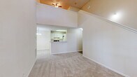 Located at 100 Walden Shores Dr in Brunswick, Georgia, this two-story residence offers a well-designed layout spread across two levels. The main floor is the heart of the home, anchored by a spacious living room with dramatically vaulted ceilings that create an expansive sense of openness. Soft carpet flooring runs throughout the living and dining areas, and a pass-through kitchen counter connects the kitchen to the living space, making the layout feel open and connected. The kitchen features white cabinetry and a practical overhead lighting setup. A dedicated dining area and a pendant-lit ceiling fan further enhance the main living space. A staircase leads up to the loft level, which provides additional flexible living space overlooking the main floor below. The generously sized bedroom offers plush carpeting, a ceiling fan, and a window with greenery views, creating a calm, comfortable retreat. Five closets throughout the home — including a walk-in — provide ample storage. The full bathroom features wood-look flooring, a white vanity with under-sink storage, a large mirror, and a combined tub and shower. A dedicated laundry area with hookups and wire shelving completes this functional and well-appointed home.
