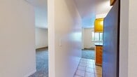 This 1050 square foot apartment in Tualatin, Oregon offers a well-designed living space with three bedrooms and three bathrooms. The single-story layout maximizes functionality, featuring an open-concept design that seamlessly integrates the kitchen and living areas. The modern kitchen is equipped with honey-colored wood cabinetry, dark countertops, and stainless steel appliances, including an electric stove and refrigerator. Tiled flooring in the kitchen and bathrooms contrasts with plush carpeting in the bedrooms and living spaces, creating a cozy atmosphere. The bathrooms feature single vanities with ample counter space and large mirrors. Each bedroom is generously sized, with the primary bedroom measuring 150 square feet. Large windows throughout provide natural light, while a sliding glass door in the living area leads to a private balcony, extending the living space outdoors. The apartment's neutral color palette and clean lines offer a blank canvas for personalization, making it suitable for various lifestyle needs.