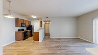 Located at Hartford Village in Columbus, Ohio, this single-floor residence offers two bedrooms and three bathrooms within a well-organized, efficiently designed floor plan. The open-concept kitchen and living area serves as the heart of the home, featuring light-toned luxury vinyl plank flooring that flows throughout the main living spaces. The galley-style kitchen is equipped with warm wood cabinetry, granite-look countertops, a black appliance suite including a refrigerator, electric range with overhead microwave, and a double sink — all complemented by ample upper and lower cabinet storage. A peninsula with a built-in sink separates the kitchen from the living area, enhancing the open feel. The living room is bright and neutral, with clean walls in a soft greige palette. Both bedrooms are carpeted and each features a sliding closet with rod and shelf storage. Natural light enters through slatted blinds in the bedroom windows. Three bathrooms include vanities with warm wood cabinetry and granite-look countertops; at least one bathroom features a full tub/shower combination. A dedicated laundry area and hallway with additional closet storage round out the practical layout of this well-appointed Columbus residence.