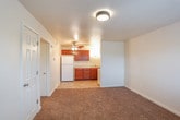 This single-floor residence offers a well-organized layout that prioritizes functionality and comfort throughout. The entryway greets visitors with light tile flooring and a front door featuring a decorative transom window, allowing natural light to filter into the space. The living area flows seamlessly from the entry and is finished with warm, plush carpeting, creating an inviting atmosphere for everyday use.

The kitchen is efficiently designed and features rich, dark wood cabinetry — both upper and lower — paired with light-toned countertops, a double-basin stainless steel sink, and a full suite of white appliances including a coil-top range, refrigerator, and dishwasher. Tile flooring in the kitchen provides a practical and easy-to-clean surface. Overhead lighting illuminates the workspace effectively.

The bedrooms are carpeted and include ceiling fans with integrated lighting for year-round comfort. The primary bedroom offers mirrored sliding closet doors, providing generous storage and a sense of added space. A window with blinds brings in natural light and garden views.

The bathroom is clean and straightforward, featuring tile flooring, a combined tub and shower enclosure, a toilet, and a vanity with cabinetry matching the kitchen. The overall aesthetic throughout the space is neutral and well-maintained, offering a move-in ready environment.
