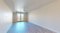 Located at 2100 Fourth Avenue in San Diego's Bankers Hill neighborhood, this thoughtfully designed 1-bedroom, 2-bathroom residence offers a generous, well-appointed single-level floor plan. Light-toned luxury vinyl plank flooring flows throughout the main living areas, complementing the bright, neutral color palette that gives the space an airy, modern feel.

The open-concept living and dining area is anchored by a ceiling fan and French doors that open onto a private balcony, flooding the space with natural light and offering views of the surrounding neighborhood. The kitchen is a standout feature, showcasing crisp white shaker cabinetry, a tile backsplash, stainless steel appliances including a gas range, microwave, and refrigerator, and a large waterfall-edge island with a built-in sink and pendant lighting above — ideal for both cooking and entertaining.

The spacious primary bedroom is finished with plush carpeting, a ceiling fan, and direct access to a generously sized walk-in closet with built-in shelving. The primary bathroom is elegantly appointed with a dual-sink vanity, backlit mirror, wood-toned flooring, and a frameless glass walk-in shower with large-format tile surround. Additional highlights include a dedicated laundry area, a pantry, and a second full bathroom.