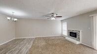 This single-story, 2-bedroom, 2-bathroom home in Sherman, Texas offers a functional and well-appointed layout with consistent neutral finishes throughout. The spacious living room serves as the heart of the home, featuring plush carpet, wood-look vinyl flooring at the entry, a ceiling fan with light fixture, a textured ceiling, and a standout stone-surround fireplace that anchors the room. A sliding glass door floods the space with natural light and provides exterior access. The kitchen is efficiently designed with gray-toned cabinetry, marble-look quartz countertops, subway tile backsplash, wood-look vinyl flooring, and white appliances including a refrigerator and range. The primary bedroom is generously sized with carpet flooring, a ceiling fan, and access to a dedicated closet and private bathroom. The primary bathroom features a wide vanity with quartz countertops, taupe cabinetry with brushed nickel hardware, a large mirror, and wood-look vinyl flooring. The second bedroom is well-proportioned with carpet, a ceiling fan, and ample natural light from dual windows. A hallway connects the rooms efficiently, and an additional full bathroom serves the second bedroom and guests. The home maintains a clean, move-in-ready aesthetic throughout.