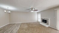 This single-story, 2-bedroom, 2-bathroom home in Sherman, Texas offers a functional and well-appointed layout with consistent neutral finishes throughout. The spacious living room serves as the heart of the home, featuring plush carpet, wood-look vinyl flooring at the entry, a ceiling fan with light fixture, a textured ceiling, and a standout stone-surround fireplace that anchors the room. A sliding glass door floods the space with natural light and provides exterior access. The kitchen is efficiently designed with gray-toned cabinetry, marble-look quartz countertops, subway tile backsplash, wood-look vinyl flooring, and white appliances including a refrigerator and range. The primary bedroom is generously sized with carpet flooring, a ceiling fan, and access to a dedicated closet and private bathroom. The primary bathroom features a wide vanity with quartz countertops, taupe cabinetry with brushed nickel hardware, a large mirror, and wood-look vinyl flooring. The second bedroom is well-proportioned with carpet, a ceiling fan, and ample natural light from dual windows. A hallway connects the rooms efficiently, and an additional full bathroom serves the second bedroom and guests. The home maintains a clean, move-in-ready aesthetic throughout.