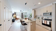 Located at 440 N Monroe St in Tallahassee, FL, this thoughtfully designed one-bedroom, one-bathroom residence offers a contemporary living experience with modern finishes throughout. The open-concept layout seamlessly connects the kitchen and living room, creating a bright and functional shared space. The kitchen is a standout feature, showcasing light wood cabinetry with matte black hardware, a subway tile backsplash, stainless steel appliances, and a central island with a built-in sink and bar seating — ideal for both cooking and casual dining. A sleek linear pendant light anchors the island. Light wood-look flooring runs throughout the main living areas, enhancing the airy, contemporary aesthetic. The living room is filled with natural light from large windows dressed with blinds and curtains, and includes a ceiling fan overhead. The bedroom offers plush carpeting, generous natural light, and a ceiling fan, providing a comfortable retreat. The bathroom is well-appointed with a dual-sink vanity featuring light wood cabinetry, a glass-enclosed shower, and large-format tile flooring. A sliding barn door leads to a dedicated walk-in closet with wire shelving, offering practical storage solutions.